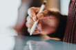© qunica.com - Detailed view of a person interacting with a digital touch screen, showcasing their hand holding a stylus for precision input in design, note-taking, or creative tasks.