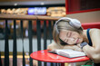 © littlepigpower - Woman is sleeping while reading a book in a coffee shop in a shopping mall