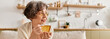 © Bliss - Senior woman enjoys warm drink at home in cozy attire during a relaxing afternoon moment