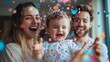 © jany sweet - Happy family celebrating gender reveal with colorful confetti indoors