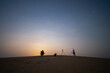 © Piak - Couple camping in the desert taking photo and relax over the sand dune desert with moon light