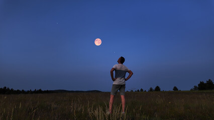 Wall Mural - amateur astronomer watching stars, moon, planets and other celestial objects from a field in nature.