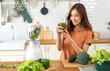 © Art_Photo - Portrait of beauty healthy asian woman making green vegetables detox cleanse and green fruit smoothie with blender.young girl drinking glass of smoothie, fiber, chlorophyll in kitchen.Diet, healthy