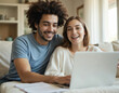 © Viktor - Young happy couple sit on sofa using laptop for finance management. Smiling homeowners review budget, pay bills online. Together they manage banking, taxes, real estate documents.