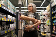 © Ivan Traimak - Stylish mature woman selects home goods in a modern retail store while shopping for cookware and decor