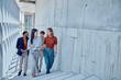 © we.bond.creations - Group of multi-ethnic businesspeople walking up stairs in modern office building while discussing about work using tablet