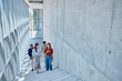 © we.bond.creations - Group of happy businesspeople walking and talking while going down the stairs in a modern office building