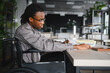 © Serhii - Focused african american student in wheelchair studying in modern library