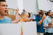 © oneinchpunch - Public demonstration on the street against social problems and human rights. Group of multiethnic people making public protest
