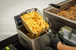 © 9parusnikov - French fries being removed from deep fryer