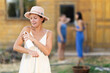 © JackF - Young woman in dress applying sunscreen outside country house