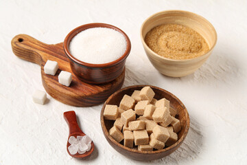 Wall Mural - Bowls different types of sugar on white background