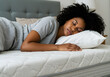 ©  marufur rashid - Young woman peacefully sleeping on a sofa, radiating beauty and relaxation in her home