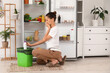 © Pixel-Shot - Young woman throwing spoiled food from open fridge in kitchen