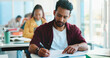 © peopleimages.com - Man, college student and writing with book in classroom for development, learning and scholarship. Person, notes and attention with project, assessment and education with solution at university