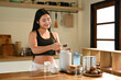 © Stella 16 - A woman is making a protein shakes in a kitchen. She is smiling and she is enjoying the process