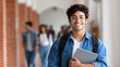 © UniqGraphicX - Young Indian male student with laptop standing in college corridor. University campus and learning lifestyle