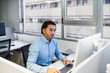 © Koldo_Studio - Focused employee working on computer in modern office, demonstrating productivity and concentration in professional environment