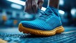 © 0108 - Athletic Shoe Close-up: Runner Tying Laces, Blue and Yellow Sneakers, Fitness Gear, Sporty Style, Active Lifestyle, Training, Exercise, Competition
