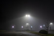 © Cavan Images - Street lights illuminate mist on a foggy night in a parking lot