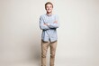 © Supanat - Happy smiling young man standing with arms crossed wearing casual shirt and pants.