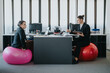 © qunica.com - A modern office scene with colleagues using fitness balls as seating while working