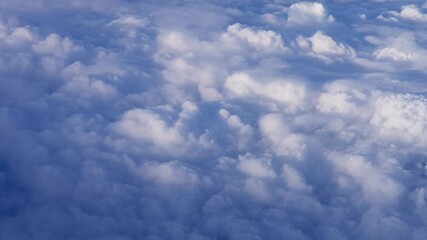 Wall Mural - aerial view above fluffy clouds, showcasing soft textures and bright sky scenery.