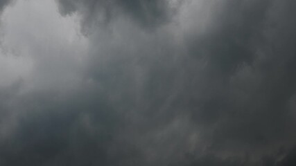 Wall Mural - Timelapse of dark gray summer storm clouds churning and drifting through the sky. The clouds fill the frame 
