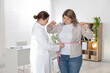 © New Africa - Weight loss. Nutritionist measuring overweight woman's waist with tape in clinic