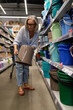 © Ivan Traimak - Middle-aged woman shopping in a home improvement store exploring various household and garden items