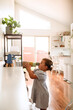 © Austockphoto - Toddler holding stacked blocks placing on countertop.
