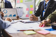 © Wasan - Business people are discussing company performance and analyzing charts and graphs showing positive growth during a corporate meeting.