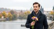 © Ibnan - Romantic man with a bouquet of flowers waiting for a date on a bridge in a historic European city