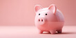 © Daniel - Pink piggy bank positioned slightly to the right on a soft pink background with a smooth texture showcasing savings concept for children and finances.