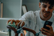 © carballo - young man cleaning or preparing vintage bicycle looking at mobile phone or app