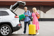 © Prostock-studio - Happy caucasian senior couple going car trip together. Cheerful elderly man and woman in casual travelers getting ready before journey by auto, loading vehicle trunk with luggage, stand outdoors