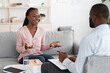 © Prostock-studio - Happy african woman talking with psychologist at private therapy session, sharing her progress, sitting on couch and smiling, free space