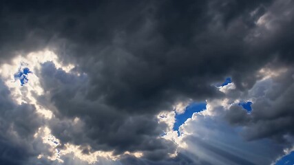 Wall Mural - cinematic 4K time lapse sunrays dramatically breaking through dark storm clouds blue sky producing breathtaking divine light effect perfect spiritual awe inspiring nature