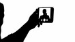 © CreativePulse Stock - Silhouette of person holding smartphone taking selfie with visible camera and screen displaying image