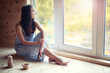 © alexkich - A girl at the window in the house