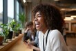 © Snap Essence - Happy african american woman laughing in modern office workplace with colleagues