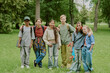 © AnnaStills - Group of diverse teenagers standing together in park, smiling and posing for camera, multiethnic boys and girls with backpacks and skateboard enjoying outdoor school activity