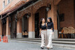 © crizzystudio - Two young women walking and smiling in urban setting