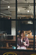 © WavebreakMediaMicro - Red-haired woman taking notes and holding takeaway coffee cup beside salad bowl at workspace