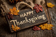 © Yurii Semonov - Rustic wooden sign with happy thanksgiving text and colorful autumn leaves