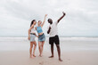 © Kiattisak - Diverse group of young friends taking selfie and enjoying time together on the beach. Fun summer vacation moment symbolizing friendship, freedom, and multicultural connection.