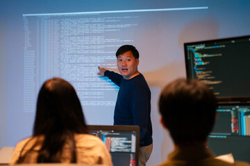 Asian software engineer or programmer team working late in development office,problem solving or algorithm of ai assistant helping for work.software developer,digital technology security concept