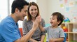 © Erisna Yolanda - A cheerful child high-fives a medical professional. The mother watches smiling, in a colorful room with sunlight and furniture
