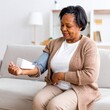 © ShutterSnap - Woman Checking Blood Pressure in Natural Home Environment – Preventive Health Concept