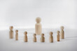© Alexa Joy - Leadership concept with wooden peg dolls on white background. Themes of teaching, management, community, or social dynamics.